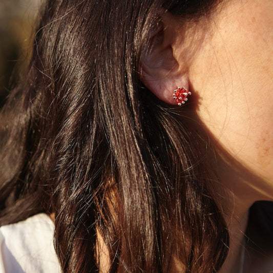 mujer con mini pendientes de presión, con forma de anémona, en plata de Ley 925 con acabado galvanizado rojo pasiónm colección Anémona de Ardentia