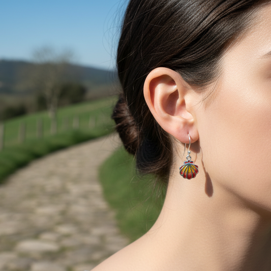 chica con pendientes de gancho móvil con concha del camino de santiago, vieira, plata de ley 925 con pigmentos rojizos, colección Fisterra Solpor de Ardentia