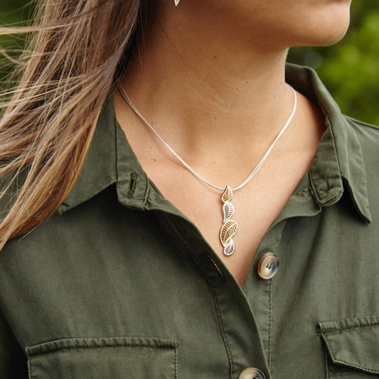 mujer con colgante Mar de Lira, con las olas de la playa de Lira, en Carnota